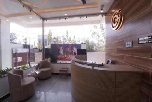 a lobby with a desk and chairs and a large window at The Oscar Grand in Lucknow