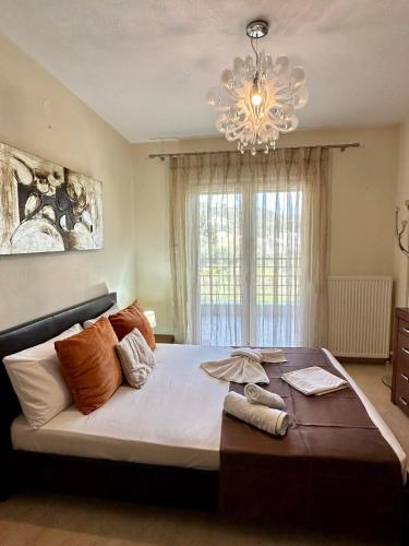 a large bed in a bedroom with a chandelier at Endless Blue Garden Villa in Paleo Tsifliki