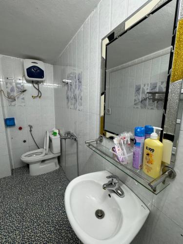 y baño con lavabo, espejo y aseo. en Nhà Nghỉ Hương Sen en Móng Cái
