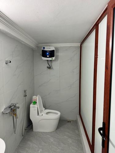 baño con aseo y TV en la pared en Nhà Nghỉ Hương Sen en Móng Cái