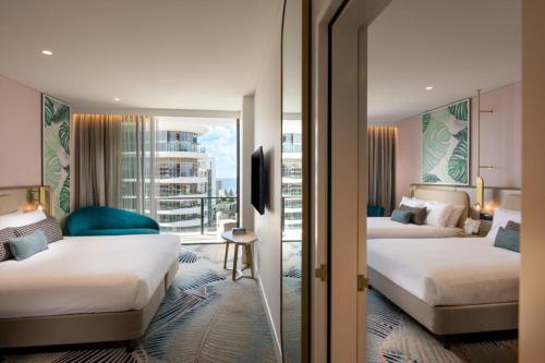 a hotel room with two beds and a window at Dorsett Gold Coast in Gold Coast