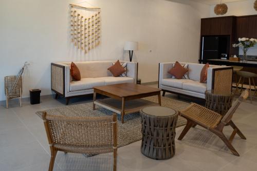 uma sala de estar com sofás, uma mesa e cadeiras em Morika Villa em Rua
