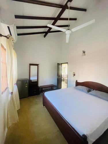 a bedroom with a large bed and a ceiling at Star Canal Cottage in Negombo