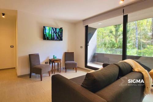 a living room with a couch and a table at Amplio Depto al Bosque en Pucón in Pucón