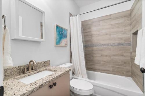 a bathroom with a sink and a toilet and a shower at Chic Downtown Home 42 And Guest Home 11 in West Palm Beach