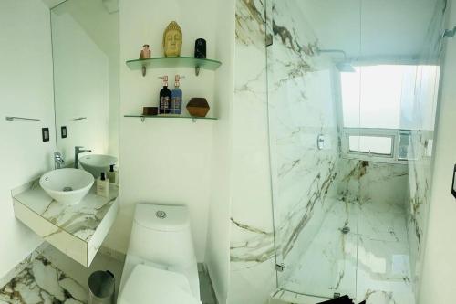 a white bathroom with a toilet and a shower at Polanco Pool Amazing view gym parking in Mexico City