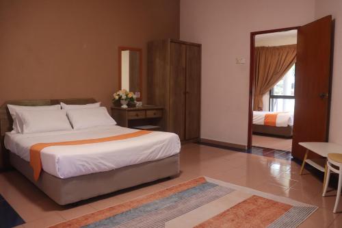 a bedroom with a large bed and a mirror at Bunga Raya Resort Parit Buntar in Parit Buntar