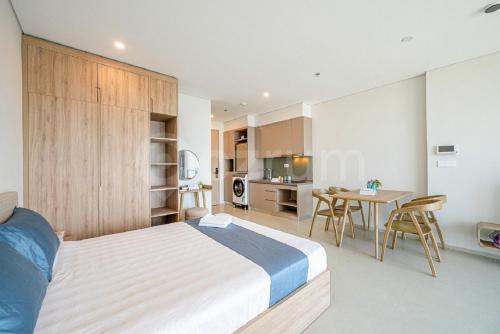 a bedroom with a bed and a table and a kitchen at Căn hộ hạng sang có bếp và ban công The Song Vung Tau - Luxury Homestay in Vung Tau