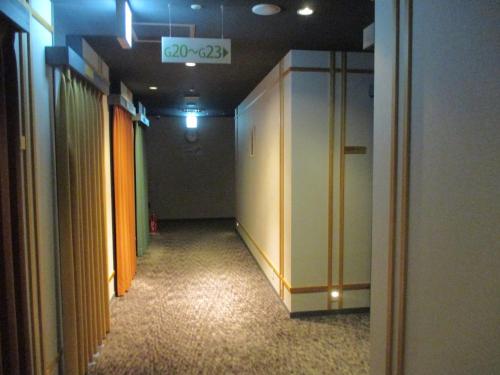 korytarz biura z pomarańczowymi drzwiami i korytarzem w obiekcie Hotel M Matsumoto w mieście Matsumoto