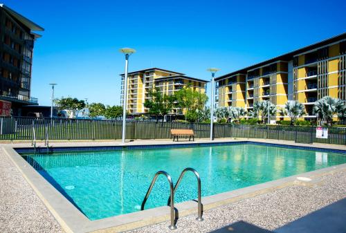 a swimming pool with a bench next to a building at Serenity Peary - Executive 1brm at Darwin Waterfront with Sea Views in Darwin