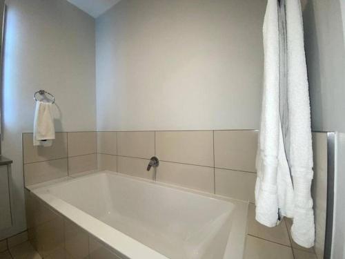 a white bath tub in a bathroom at Stunning 1 Bedroom at The Median in Johannesburg