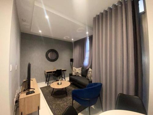 uma sala de estar com um sofá e uma mesa em Stunning 1 Bedroom at The Median em Joanesburgo