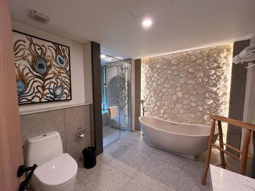 bagno con vasca e servizi igienici di Luminor Hotel Legian Seminyak - Bali a Seminyak