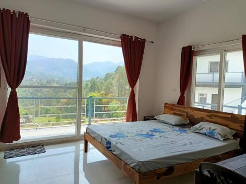 a bedroom with a bed and a large window at Trails of Bheta in Kausani
