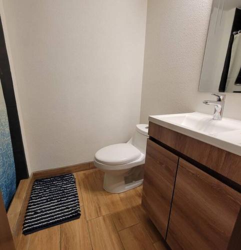 a bathroom with a toilet and a sink at Elegante apartamento cerca de Embajada de los EEUU y Cayala in Guatemala