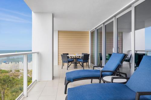 a balcony with blue chairs and a table on the beach at Marriott's Crystal Shores in Marco Island