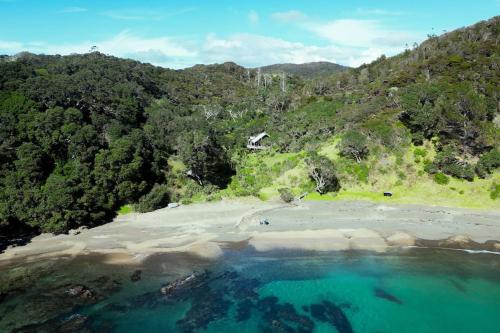 an aerial view of a beach with blue water at Whananaki Hideaway 