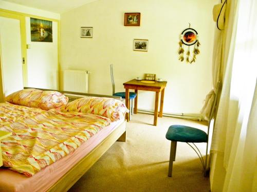a bedroom with a bed and a table and a chair at Kempink U Šerifa in Protivín