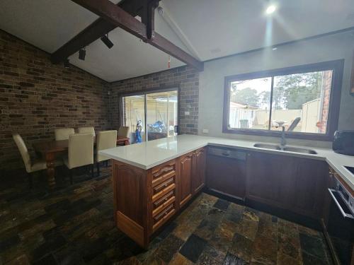 a kitchen with a counter and a sink and a table at Relax in Chipping Norton Entire Home 3 bedrooms in Chipping Norton