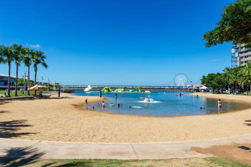 a beach with people swimming in the water at Serenity Sea La Vie - 3brm Penthouse at Darwin Waterfront in Darwin