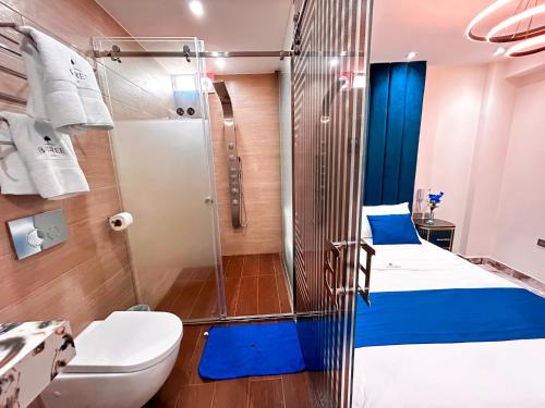 uma casa de banho com um chuveiro, uma cama e um WC. em Blue Three em Chancay