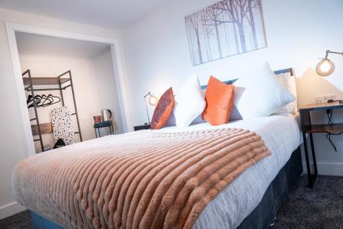 a bedroom with a bed with orange and white pillows at Kings Arms Suites - Luxury Double - Waterfall Shower - Self Check In in Whitehaven