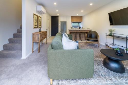 a living room with a couch and a table at Merivale Gem: 2BR Townhouse Oasis in Christchurch