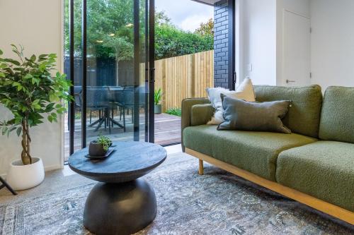a living room with a couch and a table at Merivale Gem: 2BR Townhouse Oasis in Christchurch
