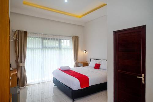 Un dormitorio con una cama grande y una ventana en RedDoorz near Ambarrukmo Area en Demangan