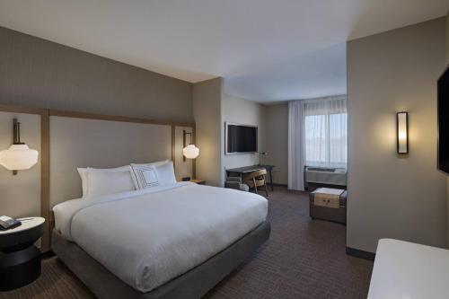 um quarto de hotel com uma cama grande e uma televisão em Fairfield Inn & Suites by Marriott Colorado Springs East em Colorado Springs