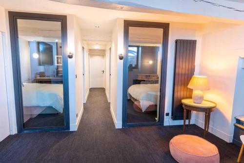 une pièce avec une chambre avec un lit et des miroirs dans l'établissement Le Lombard : Panorama sur la Garonne, à Toulouse