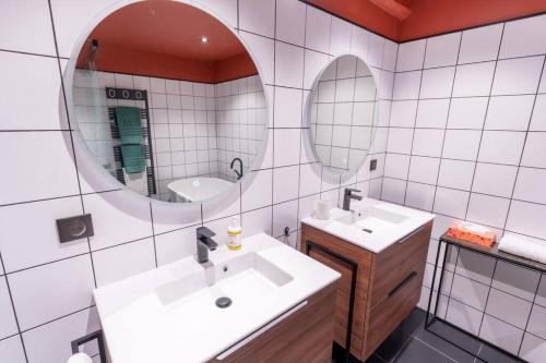une salle de bain avec deux lavabos et deux miroirs dans l'établissement Le Lombard : Panorama sur la Garonne, à Toulouse