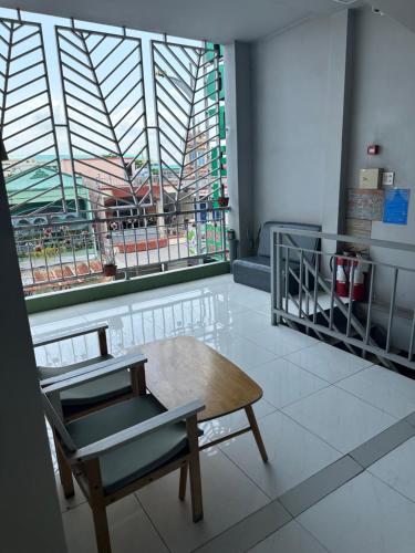 um quarto com uma cadeira, uma mesa e uma janela em KHÁCH SẠN NGUYỄN LONG em Ấp Tháp Mười