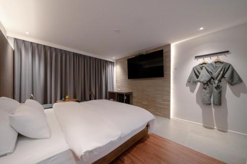 a bedroom with a bed and a flat screen tv at Siheung Brown Dot Jeongwang in Siheung