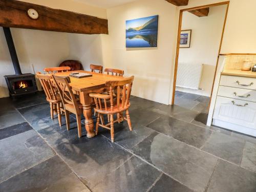a dining room with a table and chairs and a stove at Scales Cottage in Lorton