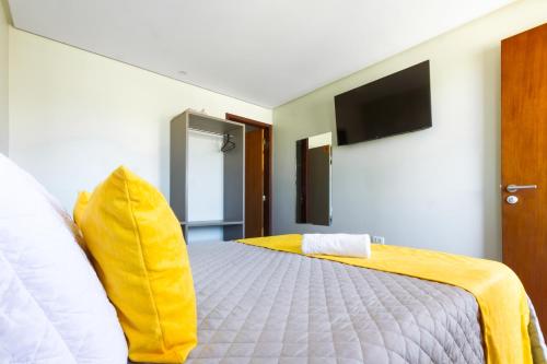 a bedroom with a bed with a yellow blanket at Pousada Maanaim Porto in Porto De Galinhas