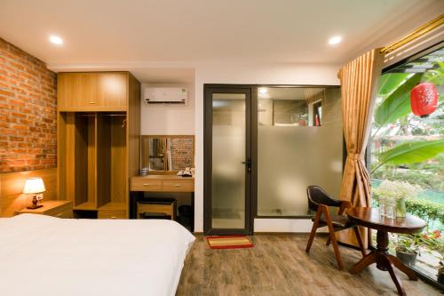 a bedroom with a bed and a desk and a table at King Kong Homestay in Ninh Binh