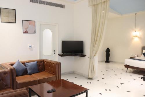 a living room with a couch and a tv at Ramee Royal Resort & Spa - Udaipur in Udaipur