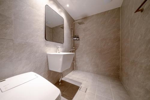 a bathroom with a white toilet and a mirror at Siheung Brown Dot Jeongwang in Siheung
