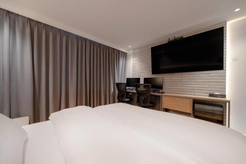 a hotel room with a large bed and a television at Siheung Brown Dot Jeongwang in Siheung