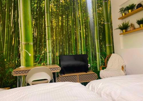 a bedroom with a bamboo wall with a bed and chairs at SnD Rentals- Studios in Kozani