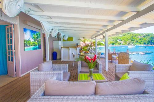 a living room with chairs and a table with flowers at Appartement élégant à Deshaies avec terrasse privée, 80 m². in Deshaies