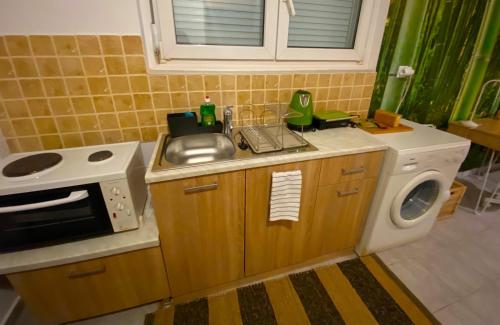 a small kitchen with a sink and a microwave at SnD Rentals- Studios in Kozani
