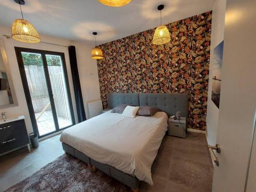 een slaapkamer met een bed en een muur bedekt met behang bij Villa de 5 chambres a Arcachon a 400 m de la plage avec piscine interieure et wifi in Arcachon