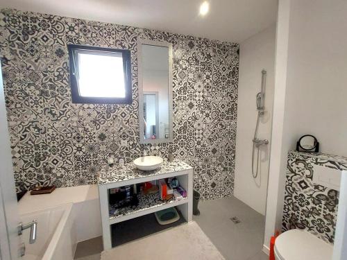 een badkamer met een wastafel en een spiegel bij Villa de 5 chambres a Arcachon a 400 m de la plage avec piscine interieure et wifi in Arcachon