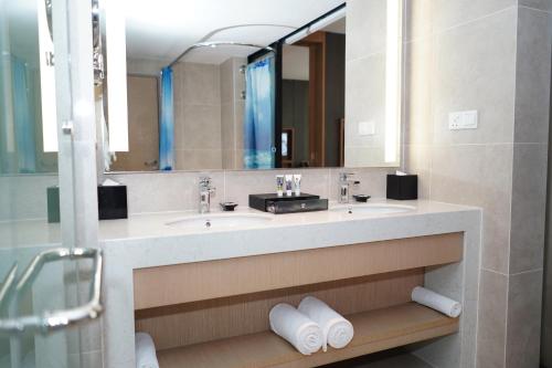 a bathroom with a sink and a mirror at Mercure Kuala Lumpur Shaw Parade in Kuala Lumpur
