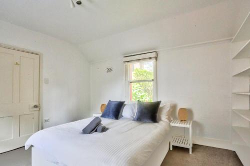 Dormitorio blanco con cama blanca y almohadas azules en Close to City 3 Bedroom House Surry Hills 2 E-Bikes Included en Sídney