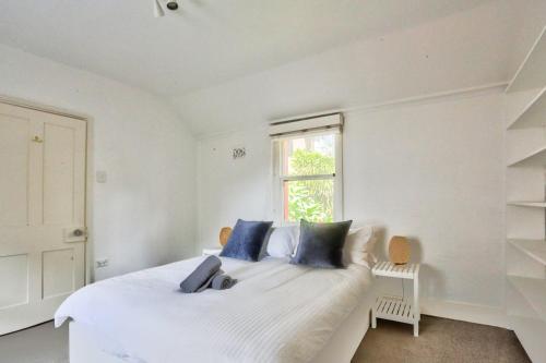 - une chambre blanche avec un lit blanc et des oreillers bleus dans l'établissement Close to City 3 Bedroom House Surry Hills 2 E-Bikes Included, à Sydney