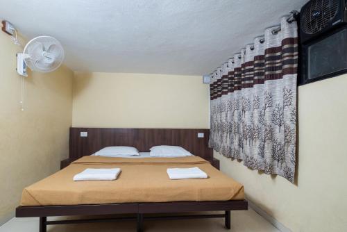 a bedroom with a bed with two towels on it at Hotel Ambika in Kolhapur