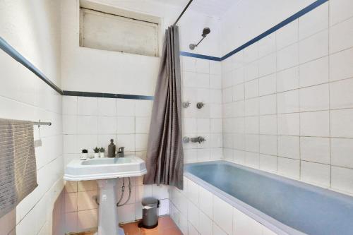 Close to City 3 Bedroom House Surry Hills 2 E-Bikes Included في سيدني: حمام مع حوض استحمام أزرق ومغسلة